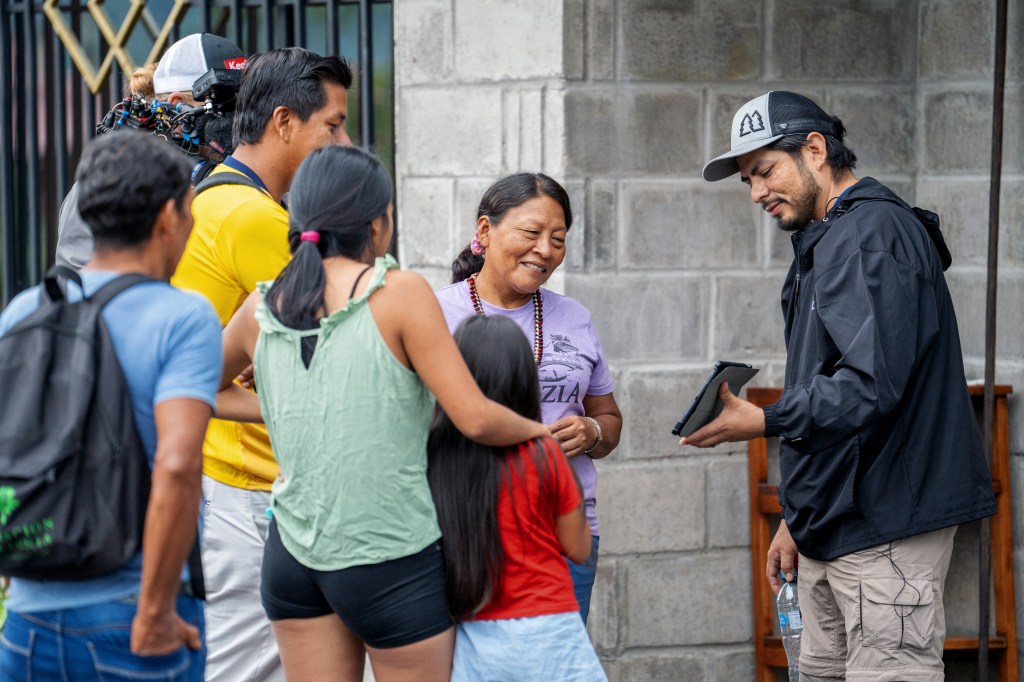 Man in a hat sharing Bible verses about missions with a small group of people.