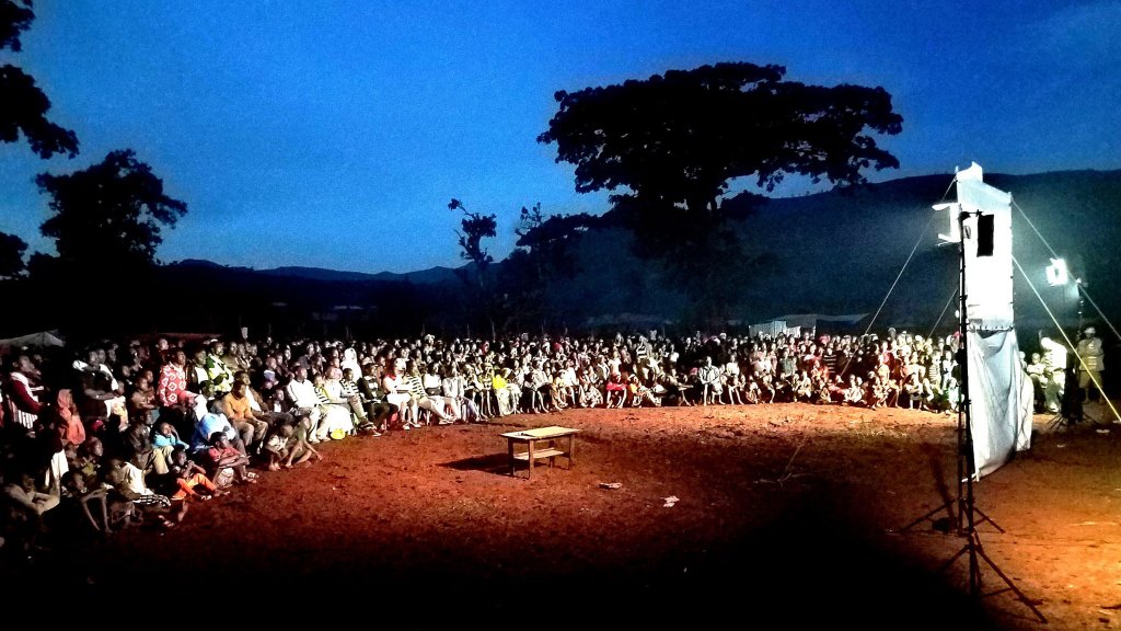 jesus film on a projector in front of a crowd in africa