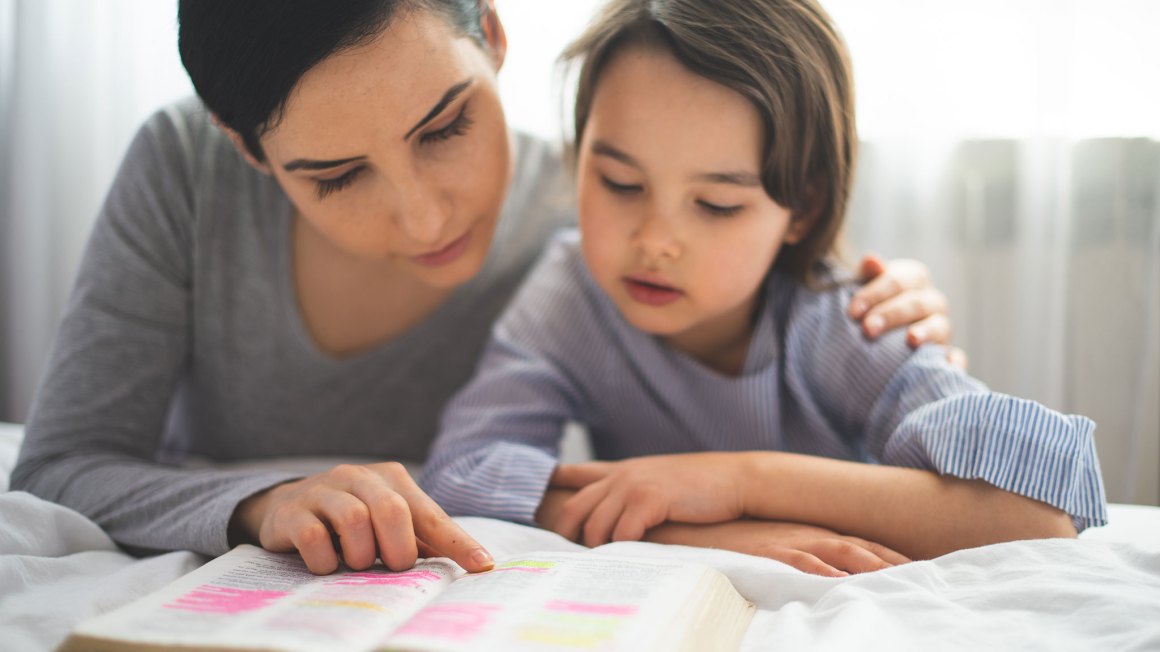 Mom and daughter reading bible together
