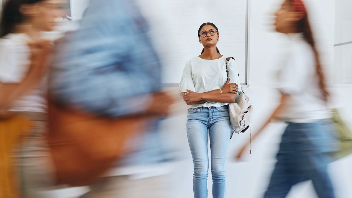 woman standing still while people are moving around her