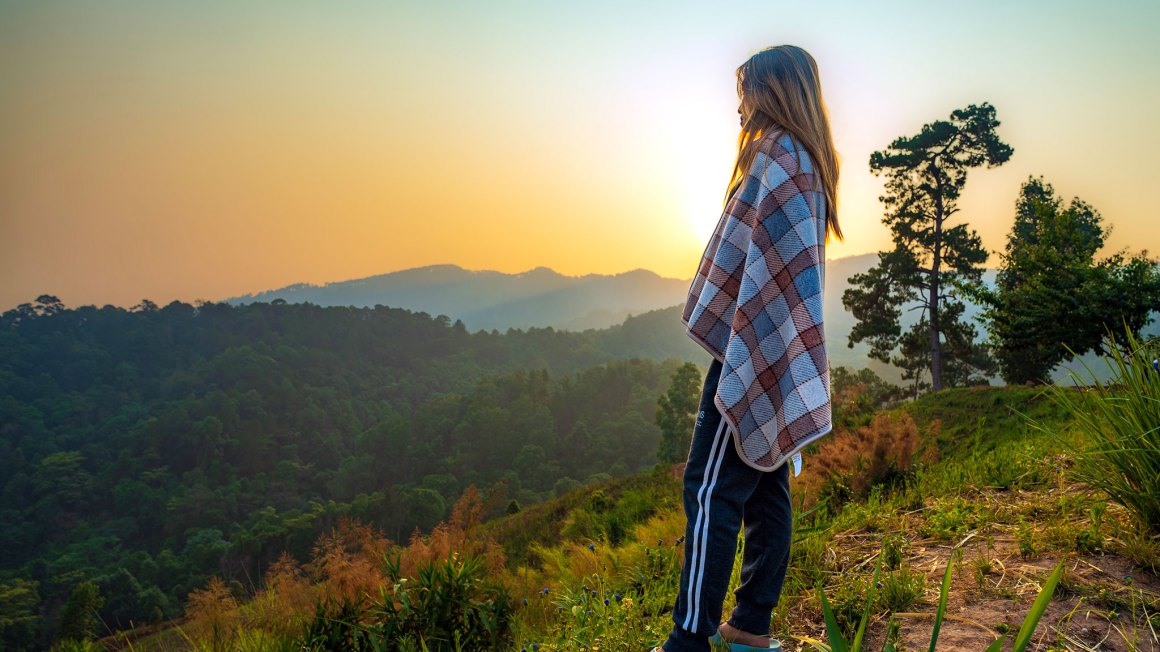 woman standing and looking at mountains