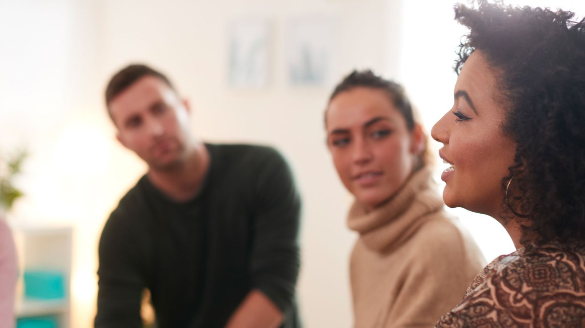 Woman speaking to a man and other woman