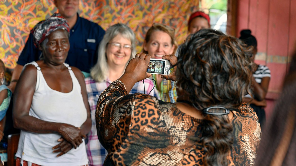 woman holding up a camera and taking pictures of other women