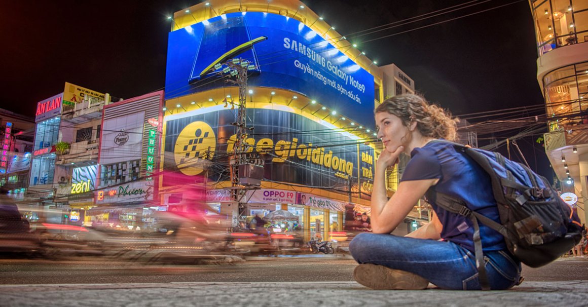 woman sitting on floor in front of a large video billboard