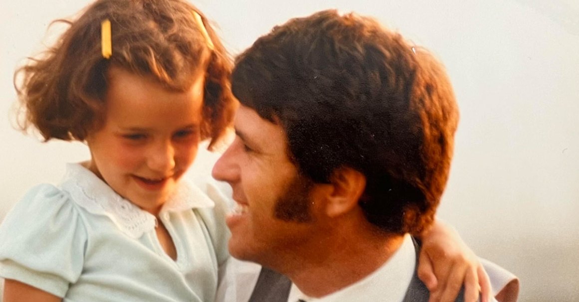 An older picture of a father holding his daughter up