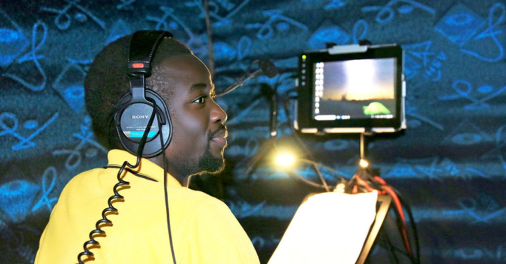 A man in an audio booth looking back