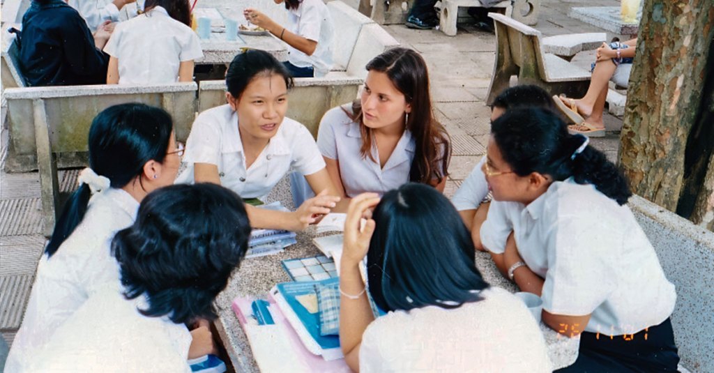 A group of thailand students sitting around a table and talking