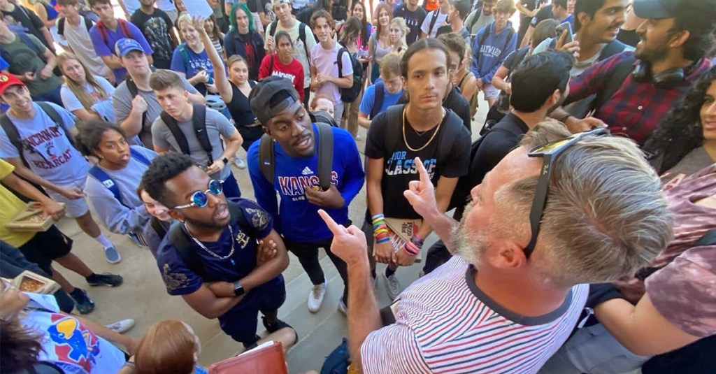 Keith Darrell up close and personal with hecklers. His street preaching reaches many ears every year.