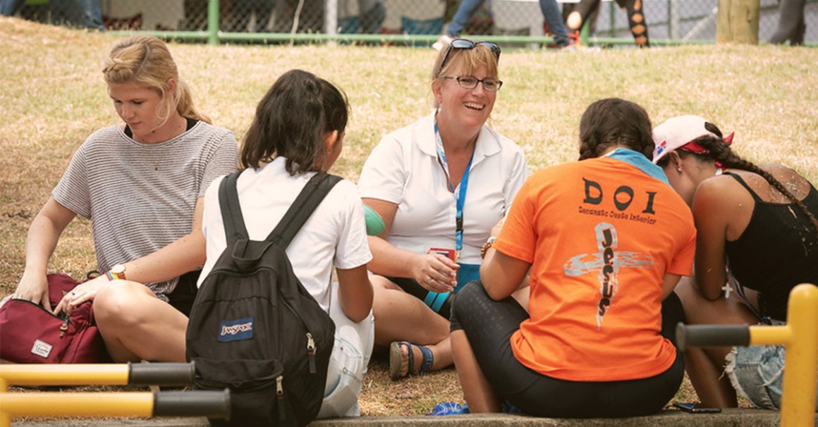 A blond cheerful woman engaging in street evangelism at a park