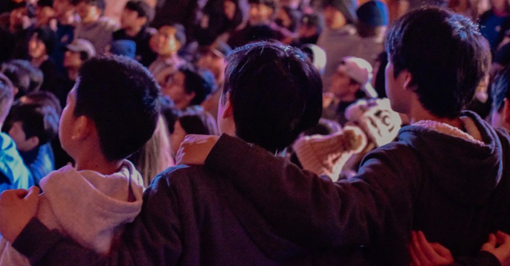 three boys stand together at a child and youth evangelism event