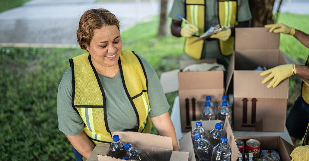 A woman provides water bottles to those in need. Evangelism through humanitarian aid is made possible by these volunteers.