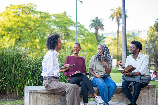 Group of two men and two women talking with their Bibles open.